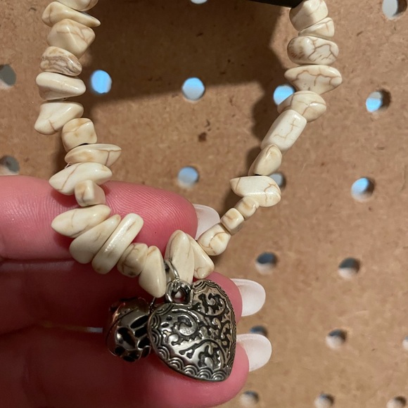 Stretchy bracelet w/off white crackle jagged stones & silver charms.